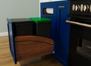 A blue kitchen cabinet drawer is open, revealing two black bins and a paper towel holder above them.